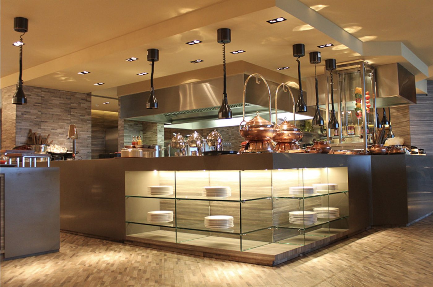 Live cooking island with glass display shelves and copper chafing dishes